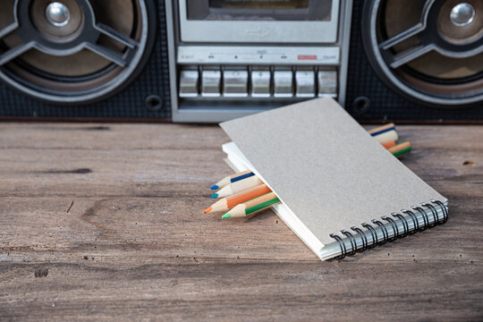 Drawing book and color pencil splaced in front of the tape player