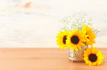 Top view image of sunflowers over wooden table and white background