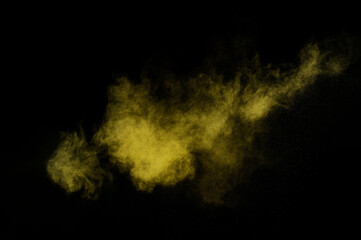 Obraz na płótnie Canvas Yellow powder explosion on black background. Colored powder cloud. Colorful dust explode. Paint Holi.