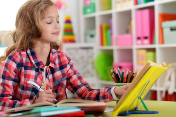 Cute teen girl doing homework in her room