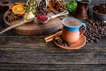 Coffee in a traditional mug and coffee beans on the wooden table