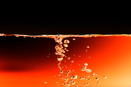 Red Color Rainbow Paint Drops From Above Mixing In Water.