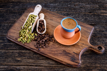 Coffee in a traditional mug and coffee beans on the wooden table