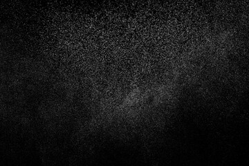 Abstract splashes of water on black background. Freeze motion of white particles. Rain, snow overlay texture.