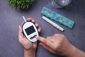 Women hand measuring diabetic glucose level at home 