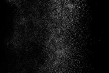 Abstract splashes of water on black background. Freeze motion of white particles. Rain, snow overlay texture.
