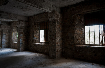 Empty abandoned room with bright light entering the windows