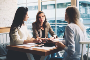 Modern three female colleagues brainstorming about work