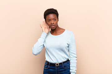 young pretty black womanlooking serious and curious, listening, trying to hear a secret...