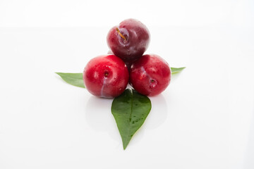 plums with plum leaves isolated on a white background