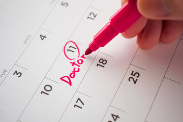important doctor appointment schedule write on white calendar page date close up