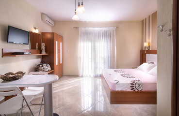 Romantic style interior of simple modern design bedroom with wooden furniture in white and beige apartment hotel room
