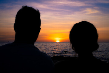 Couple looking the sunset on the beach.