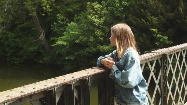 Bored Young Teenage Girl Daydreaming on a Bridge Looking into Distance and Thinking about Romantic stuff.