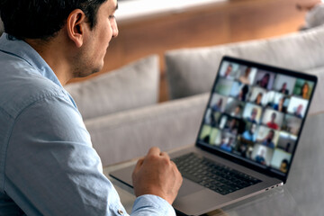 Man in a video conference with his team. Working at home with a laptop.