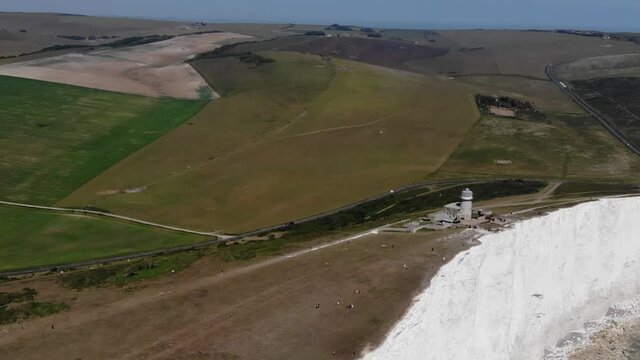 Aerial view approaching Belle Tout Lighthouse on a sunny summer day