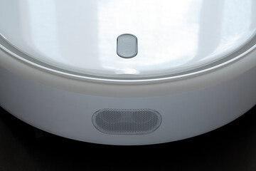 Modern white robot vacuum cleaner isolated on black background. Technology concept. Smart home concept. Hygiene concept.