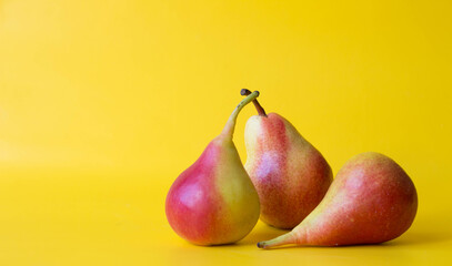 Three red yellow fresh pears isolated on  yellow background.