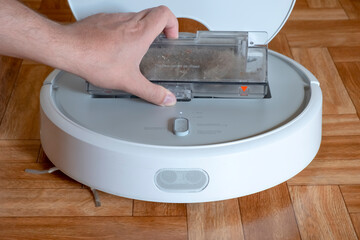 Cleaning the robot vacuum cleaner dust bin, robot vacuum cleaner maintenance service. Cleaning the...