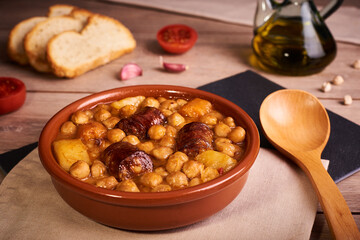 Chickpeas with spicy sausage cooked in a clay pot. Typical spanish food.