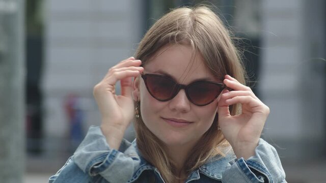 Portrait of a Happy Teenage Girl Wearing Sunglasses in City.