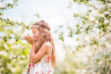 Adorable little girl in blooming apple garden on beautiful spring day