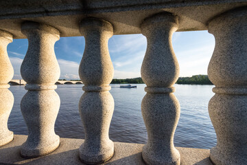 Fototapeta premium Potomac River as seen through bridge columns with boat and Arlington Memorial Bridges.