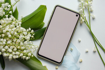phone mockup with spring blossom.  digital invitation with lily of the valley