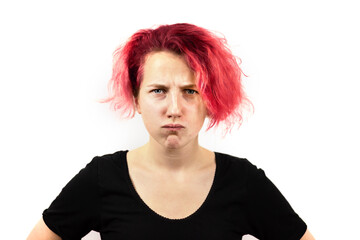 Close-up of a sad girl with disheveled red hair, looking disappointed and angry at the camera. On a white isolated background. Emotions of anger and frustration. Bad hair day
