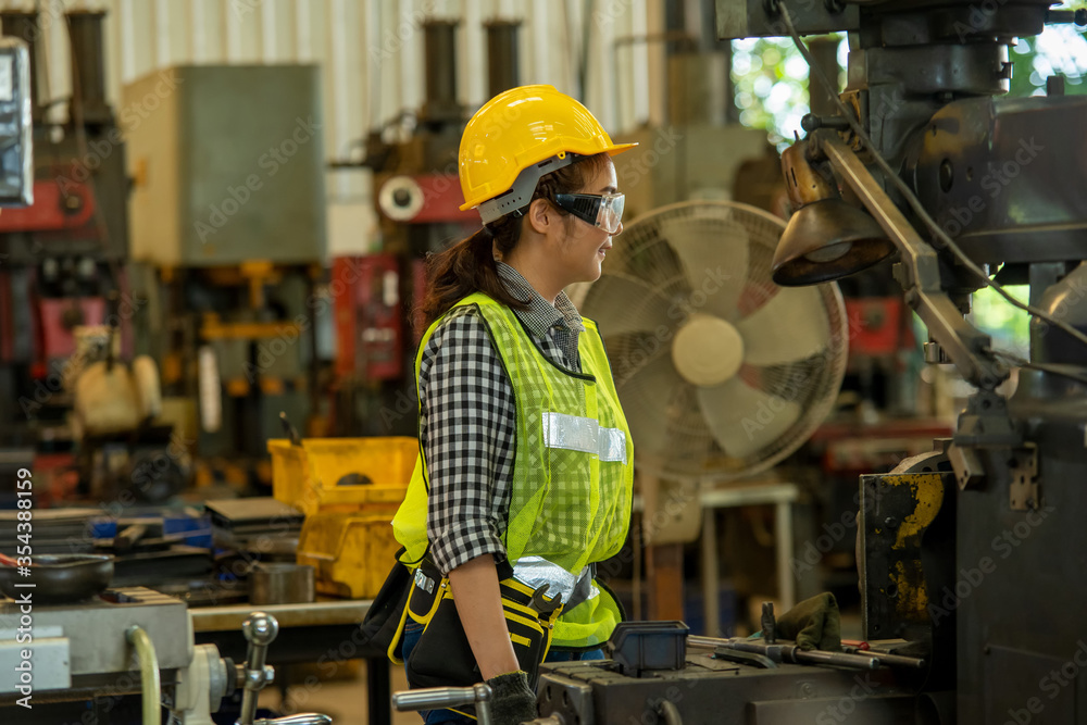 Poster female mechanic working and checking machine in factory.