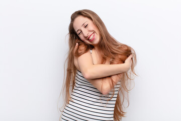 yound blonde woman feeling in love, smiling, cuddling and hugging self, staying single, being...