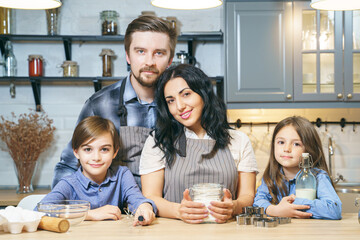 Obraz na płótnie Canvas Portrait of a happy family cooking cookies in the kitchen