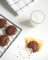 bited dark chocolate cookies on baking tray serving with a glass of milk. concept of delicious homemade dessert or snack good for kids and party.