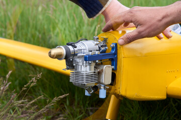 A man tests the motor before launching a radio-controlled aircraft.