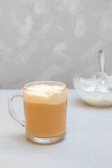 Cup of cheese tea on grey background. Black tea with cream cheese foam