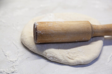 The dough and rolling pin are on the table. Cooking baking