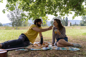 A couple having a picnic in the middle of nature. Having breakfast and enjoying the day.
