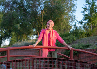 Strong woman wearing scarf in the city with breast cancer awareness