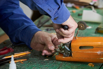 A man repairs a cordless model of an airplane before flying.