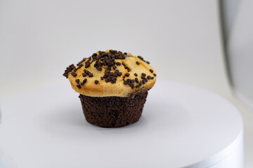 Classic muffin with chocolate drops on a white background. Sweet tasty calorie food. Closeup photo of cake