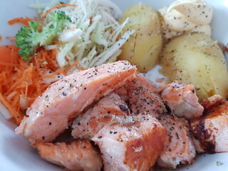 fresh norwegian salmon dinner on plate with potatoes, salad and quark