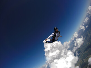 Skydiver jumping free with the clouds.