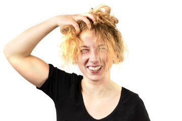 Close-up of a disheveled girl, laughing, holding her head and smoothing her hair. Isolated on a white background. The concept of emotions of joy