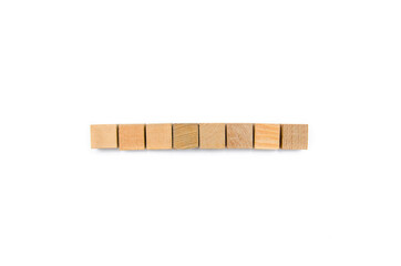 Wooden cubes on a white background. Eight identical cubes lie in a row together in the middle