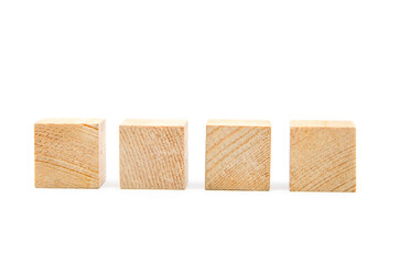 Wooden cubes on a white background. Four identical cubes lie, stand in a row together and separately, directly and at an angle. Place for text