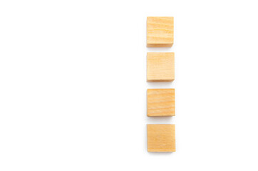 Wooden cubes on a white background. Four identical cubes lie on a table vertically with a distance between