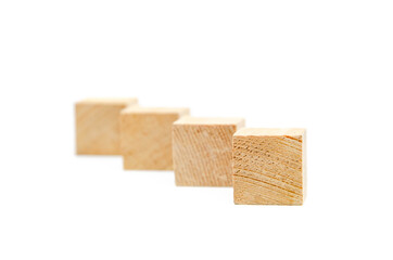 Wooden cubes on a white background. Four identical cubes lie, stand in a row along the diagonal