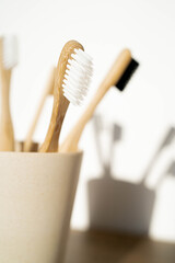 Eco-friendly bamboo toothbrushes on wooden background. Natural organic bathroom beauty product concept. Flat lay, top view, copy space.