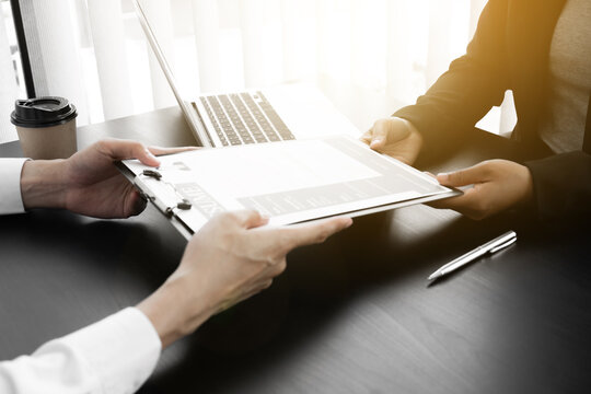 Job seeker handing a resume to interview employee for job interview in the office