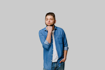 Happy handsome man wins online bet and making crazy emotions. Caucasian man wears denim shirt and put his head on fist . Isolated white backround. Online work at home quarantine concept